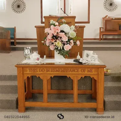 Meja altar perjamuan kudus minimalis dari kayu jati dengan ukiran tulisan rohani di bagian panel depan.